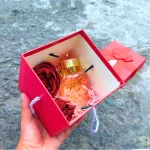 Hộp quà giấy vuông đỏ nắp rời, quai xách, có hoa kim tuyến, rơm và đèn đom đóm