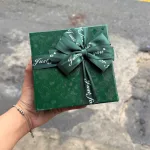 Hộp quà giấy vuông đỏ nắp rời, quai xách, có hoa kim tuyến, rơm và đèn đom đóm