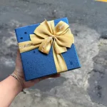 Hộp quà giấy vuông đỏ nắp rời, quai xách, có hoa kim tuyến, rơm và đèn đom đóm