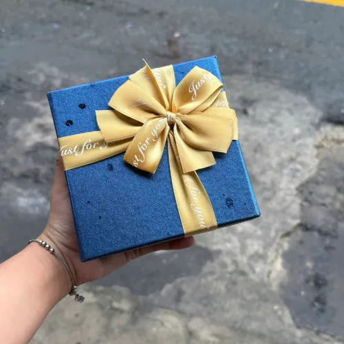 Hộp quà giấy vuông đỏ nắp rời, quai xách, có hoa kim tuyến, rơm và đèn đom đóm