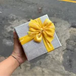 Hộp quà giấy vuông đỏ nắp rời, quai xách, có hoa kim tuyến, rơm và đèn đom đóm